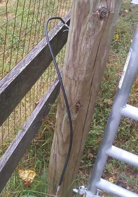 Picture of insulated electric fence wire dangling toward the ground. This is a quick fix for electric fences that show zero voltage.